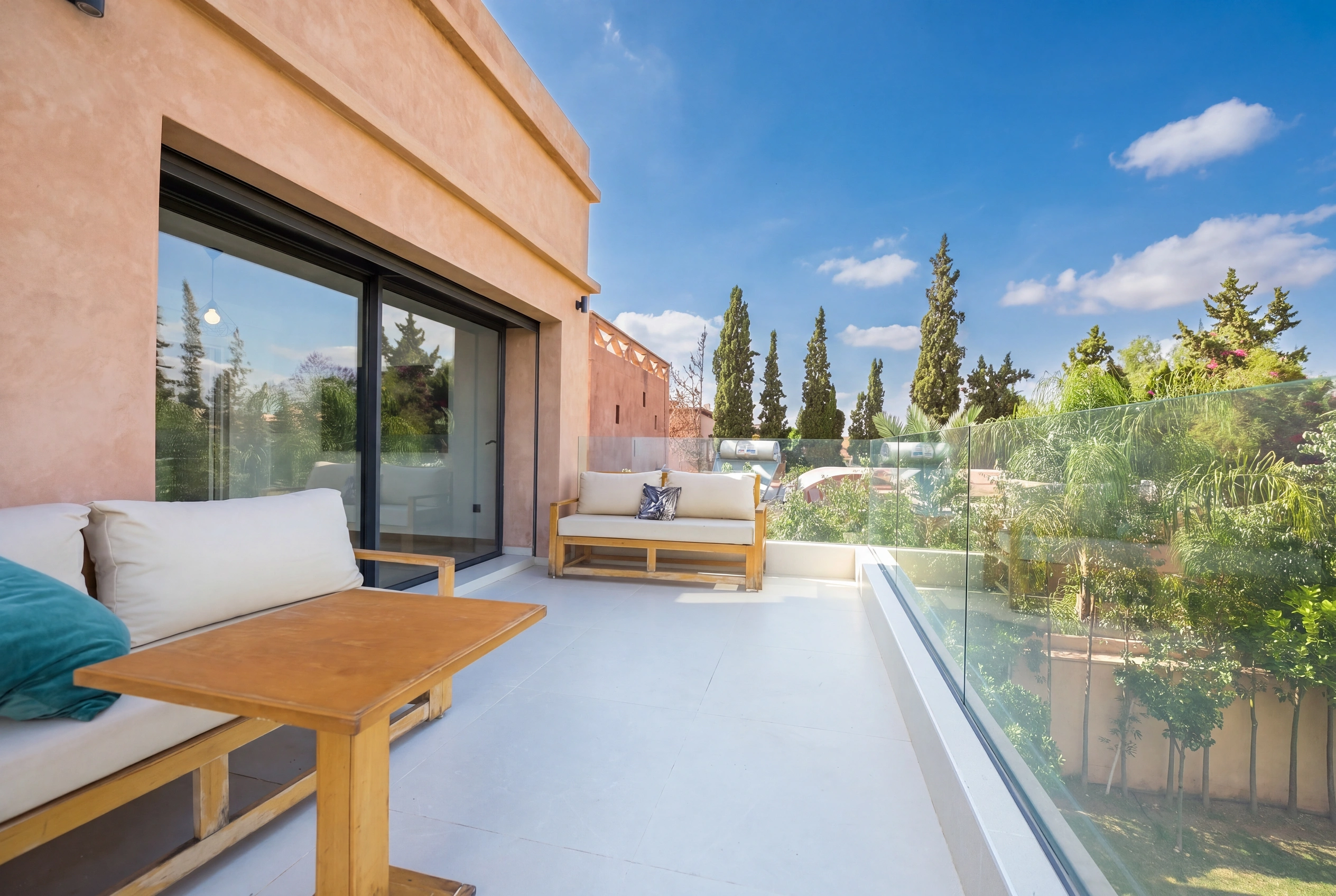 Villa Adam — Upper terrace outdoor lounge with glass railing and garden view